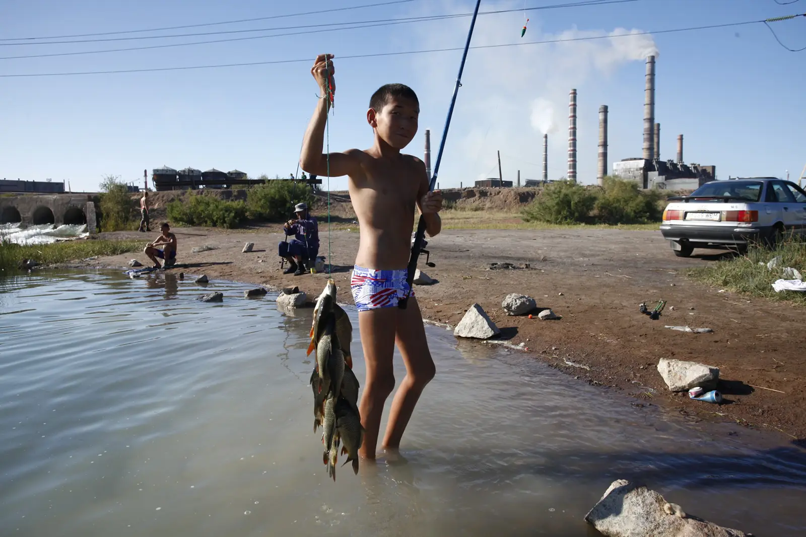 Boy holding fish he caught in lake Balkash